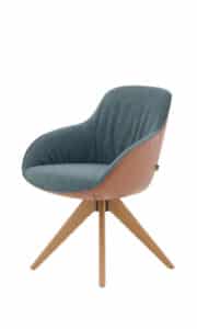 Designstuhl mit blauer Stoffpolsterung und brauner Lederaußenseite. Der Stuhl steht auf einem stabilen Holzgestell mit vier schräg ausgestellten Beinen. Die Kombination aus Materialien und Farben verleiht ihm einen modernen, stilvollen Look – ideal für Wohn- oder Arbeitsbereiche