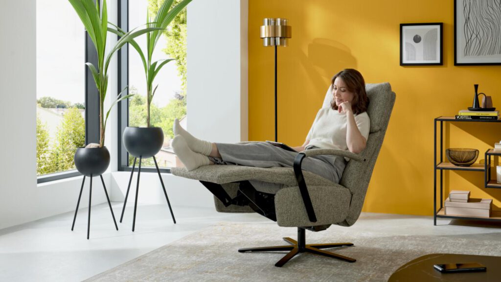 Graue Sessel von Interliving 4465 vor gelber Wand. Schön Dekoriert mit ein paar Bildern.