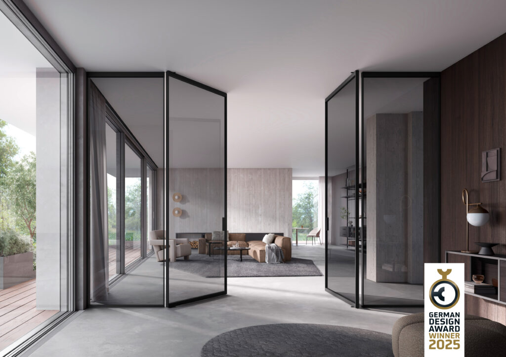 Modernes Wohnzimmer mit großen Glas-Falttüren, braunem Sofa, Designmöbeln und Holzterrasse – ausgezeichnet mit dem German Design Award 2025
