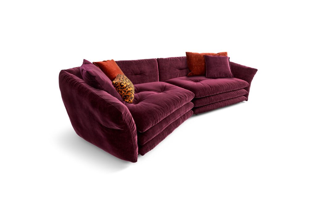 Modulares Manyara-Sofa von Bretz in tiefem Burgunderrot mit Samtbezug und Kissen in Orange, Burgunder und Leopardenmuster – luxuriös, weich und ausdrucksstark.