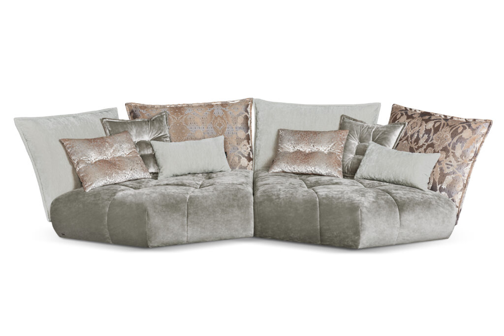 Modulares Matilda-Sofa von Bretz in silbergrauem Samt mit fünfeckigen Sitzelementen und opulenten Rückenkissen – außergewöhnliches Design mit künstlerischer Formensprache.