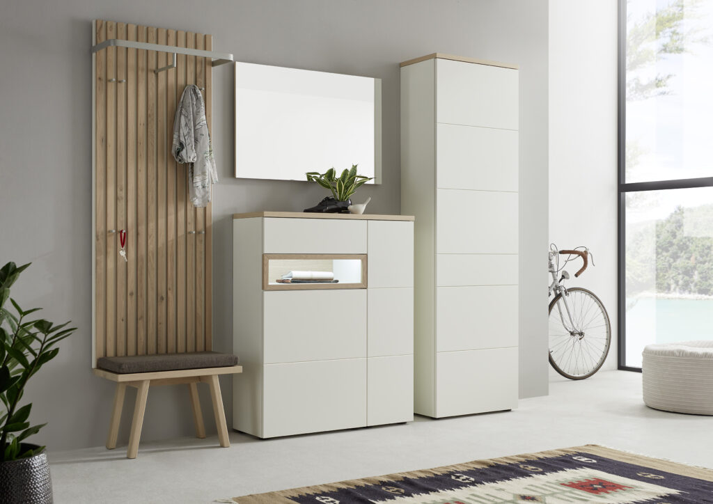 Heller Eingangsbereich mit Holzpaneel, gepolsterter Sitzbank, weißem Schrank und großem Spiegel – moderne Flurgestaltung mit Blick ins Grüne und dekorativem Teppich.