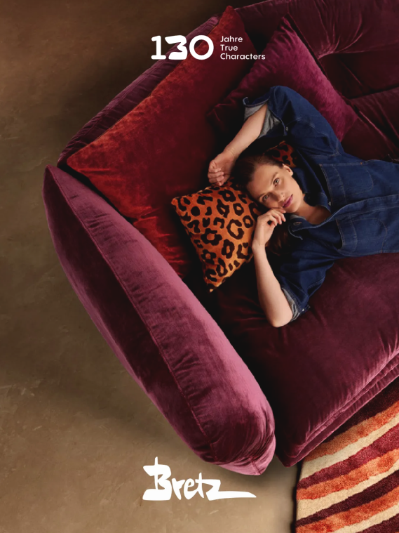 Person auf weinrotem Samtsofa mit Leopardenkissen – Kampagnenmotiv zum 130-jährigen Jubiläum von Bretz mit dem Schriftzug ‚130 Jahre True Characters‘ und Bretz-Logo.