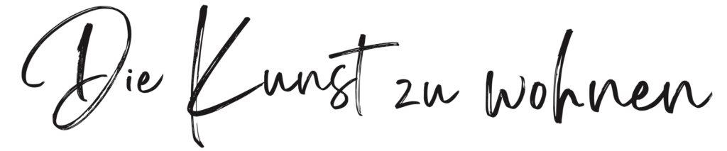 Handschriftlich geschriebener Schriftzug „Die Kunst zu wohnen“ in geschwungener, kursiver Schrift. Der Text steht allein im Bild und vermittelt eine stilvolle, wohnliche Atmosphäre.