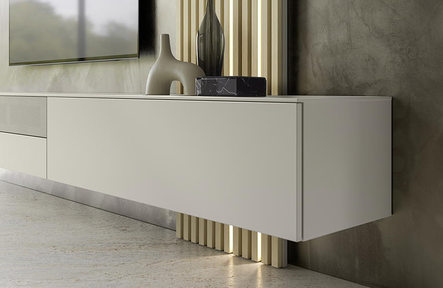 Modernes, minimalistisches Interieur mit einem weißen, wandmontierten Schwebe-Sideboard mit glatter Oberfläche und klaren Linien. Auf dem Sideboard stehen dekorative Objekte, darunter eine skulpturale Vase und eine rechteckige schwarze Marmorbox. Die Hintergrundwand ist strukturiert und mit vertikalen Holzlamellen sowie integrierter Beleuchtung gestaltet. Darüber ist ein Flachbildfernseher angebracht. Der Boden besteht aus poliertem Beton und unterstreicht den modernen Stil des Raumes.