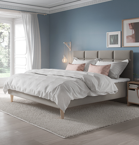 Stilvolles Schlafzimmer mit hellblau gestrichener Wand, rosa Kissen und großem Fenster; gemütlich und minimalistisch eingerichtet für ein harmonisches Wohngefühl